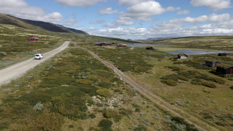 Aerial-drone-shot-of-car-driving-in-the-mountains-valley-road-of-Norway