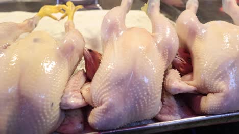 sequence of raw chickens being seasoned