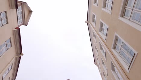 tourists walking on cobblestone streets at tallinn old town in estonia. tilt-down, wide shot