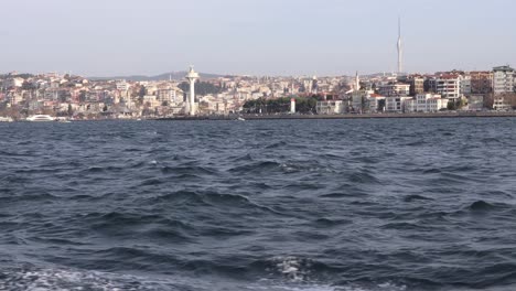 vista desde un barco navegando en el bósforo con edificios de la ciudad y torres en uskudar, estambul, turquía