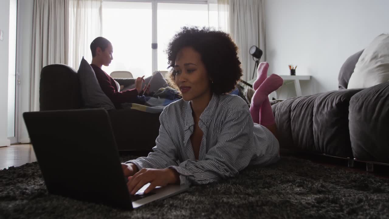Lesbian couple using laptop in living room