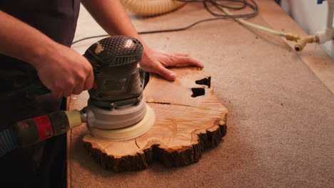 Woodworking specialist in furniture assembly shop using angle grinder