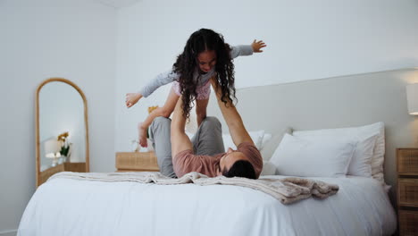 padre e hija jugando en la cama