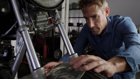 male mechanic repairing motorbike in repair garage 4k