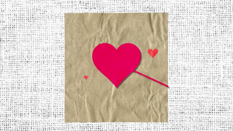 corazones rojos con flecha en papel con textil