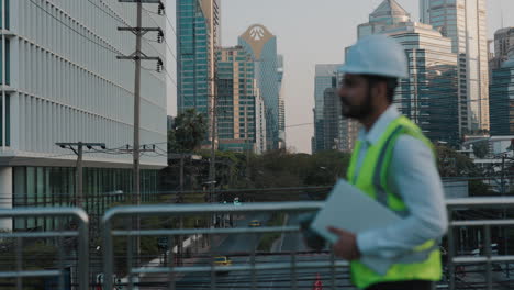 engineer walking across city bridge