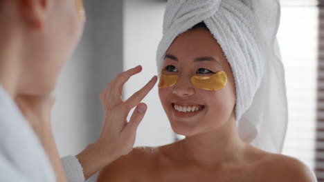 mujer aplicando parches de oro en los ojos