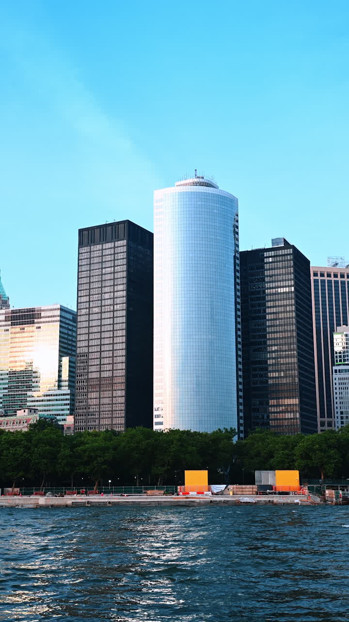 Boat trip by the East River in New York, USA. View on the green waterfront and high-rise buildings of metropolis. Vertical video