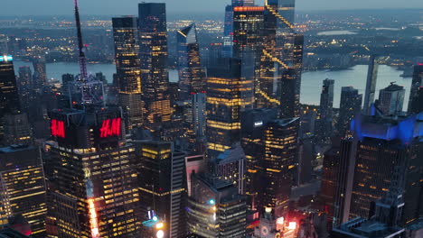 medium aerial shot around high-rise in times square and hudson yards, dusk in ny