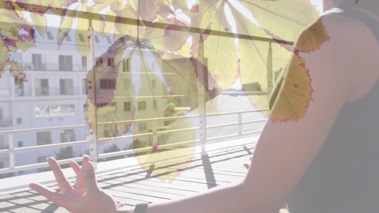 animación de hojas de árbol sobre mujer biracial practicando yoga.