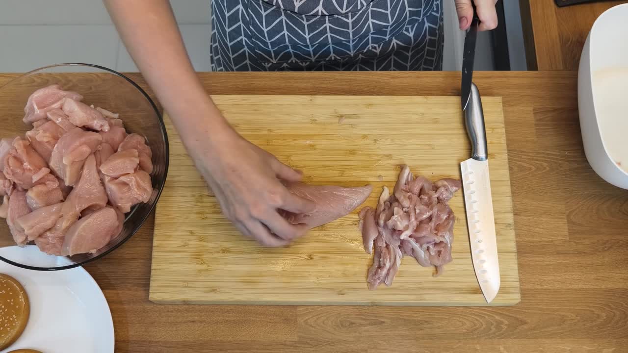 женщина, разрезающая куриную грудь.