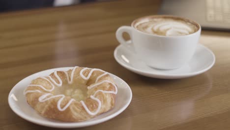 coffee and danish pastry on a wooden table