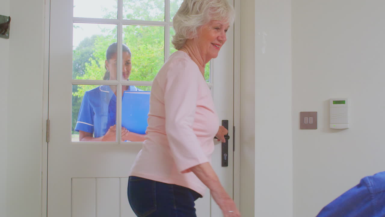 ⁇ 체어 에 앉은 남자 와 함께 한 노인 부부 가 여자 간호사 나 돌봄 종사자 를 인사 하고 집 방문 을 하고 있다