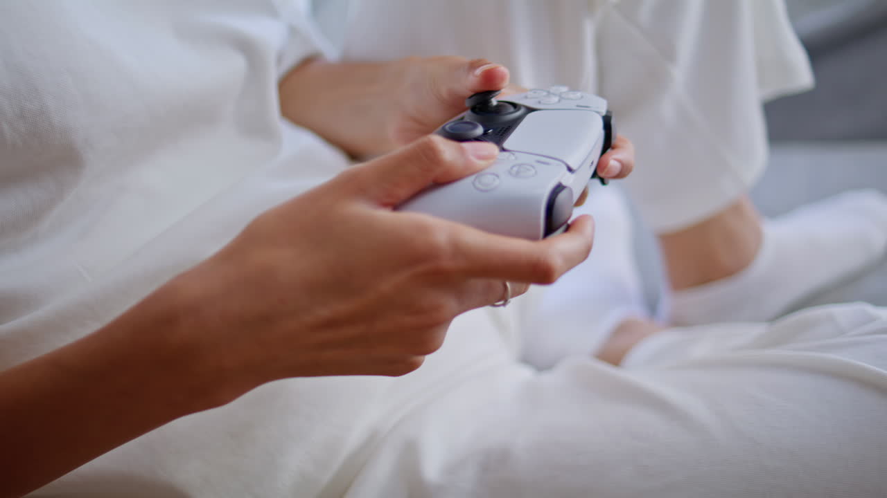 Hands video player holding console enjoying online game at home indoors closeup