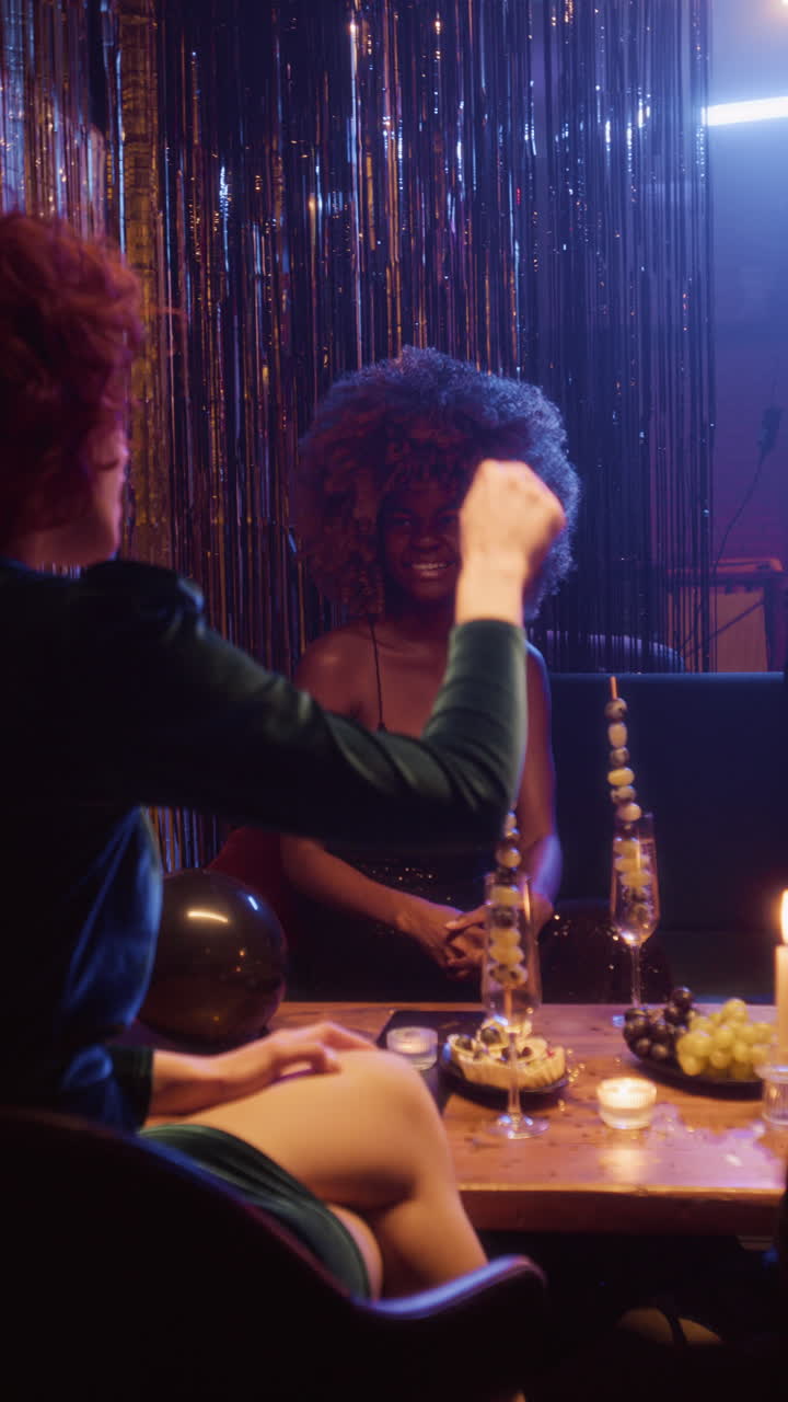 Two Women Enjoying a Party with Drinks and Desserts