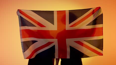 silhouette of people holding the union jack flag