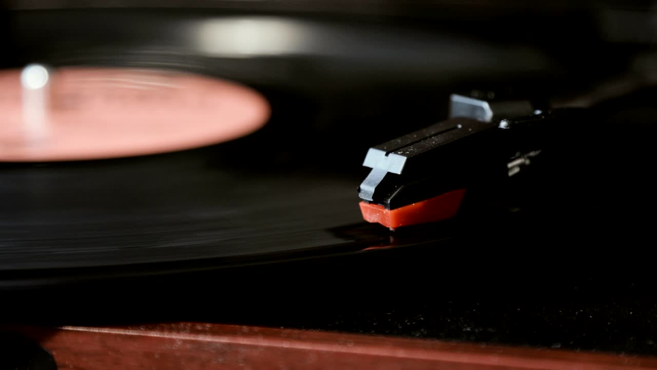 고대 비닐 레코드 플레이어를 사용하는 클로즈업. 턴테이블 플레이어, 비닐 레코드를 재생하는 스타일러스 바늘을 떨어뜨리는