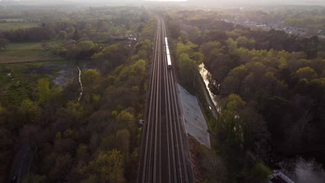 Weitwinkelaufnahme-Eines-Zuges,-Der-Bei-Sonnenuntergang-Durch-Die-Natur-Fährt