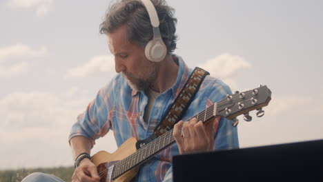 hombre tocando la guitarra acústica al aire libre