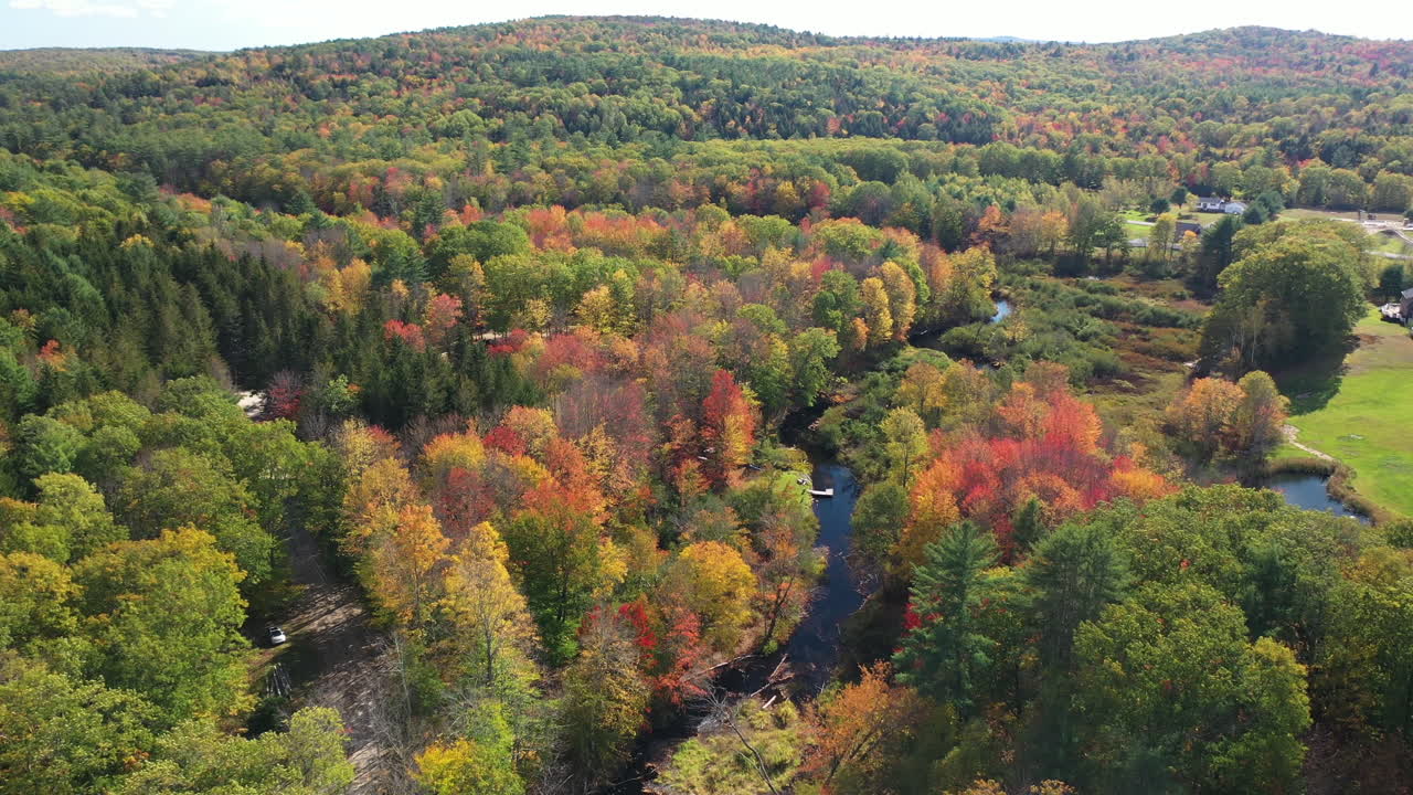 vista aérea del colorido bosque caducifolio, casas de campo y arroyo en maine usa