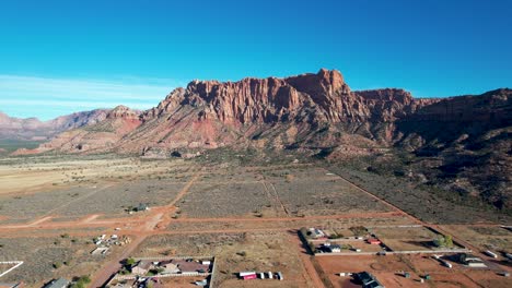 red rock cliffs above colorado city, utah town -drone zoom in