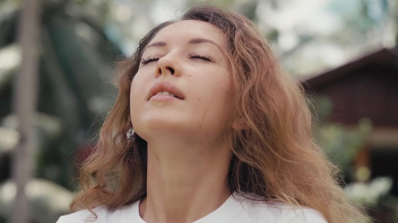 Giovane donna che si toglie la mascherina e respira aria fresca all'aperto