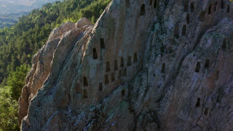 ascending pedestal drone shot of a beehive-like trapezoid niches of eagle's rock or more commonly known as orlovi skali, located in rhodope mountain in the countryside of bulgaria