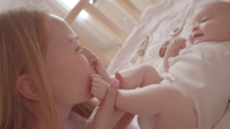 mother kissing her baby's foot