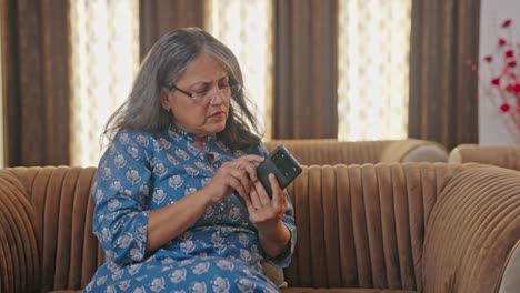 Aged-Indian-woman-trying-to-use-phone-for-the-first-time