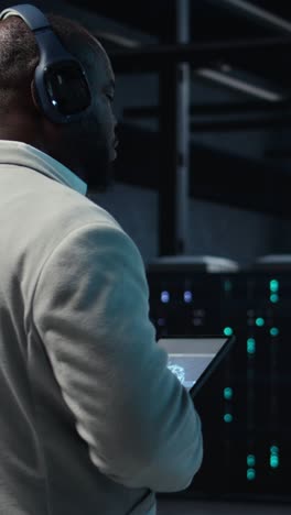 vertical video software developer in data center workspace coding on tablet