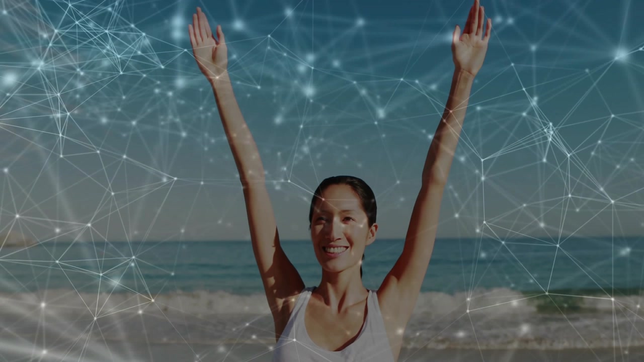Responding to overlay, Chinese woman raising arms toward sky on sandy beach, with white tank top