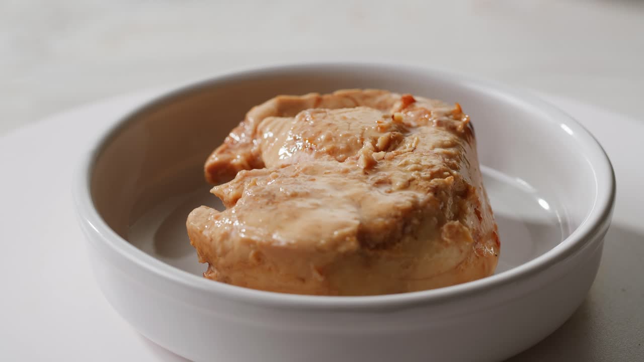 Smoked cod liver in oil in open tin can with fresh greens on wooden table. Seafoods delicacy. High quality 4k footage
