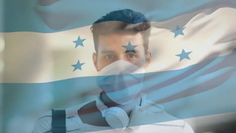 Animation-of-flag-of-honduras-waving-over-man-wearing-face-mask-during-covid-19-pandemic