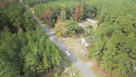 derelict cabin in woods by roadside orbiting aerial