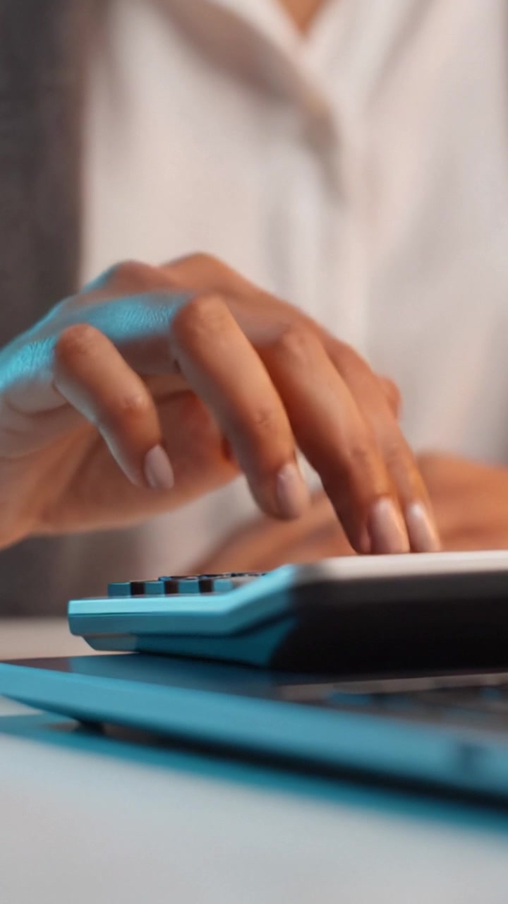 Calcolo mirato: una vista ravvicinata di mani che usano una calcolatrice per un input numerico accurato in un contesto professionale.