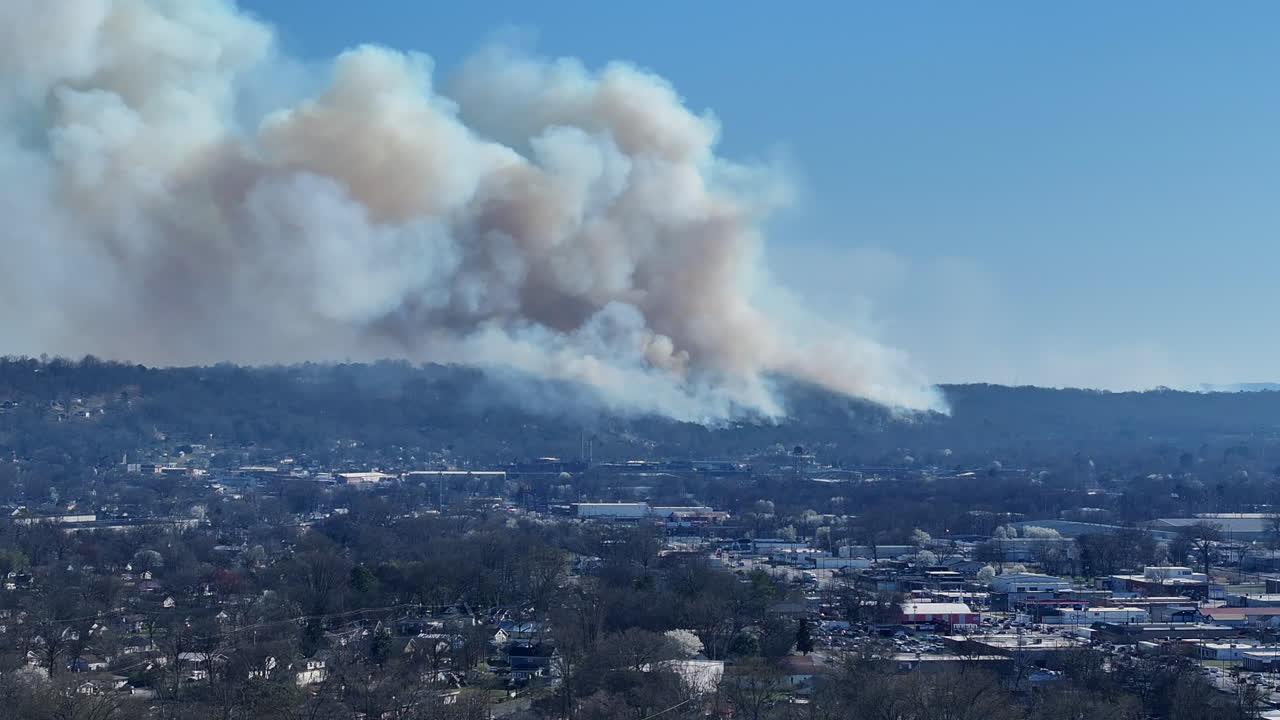 Telephoto aerial drone footage of the large smoke of a wildfire in Rossville, Georgia.
