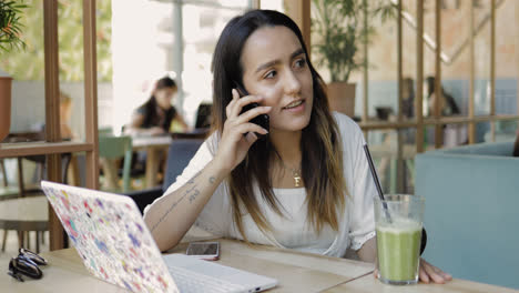Young-woman-sitting-listening-to-a-mobile-call