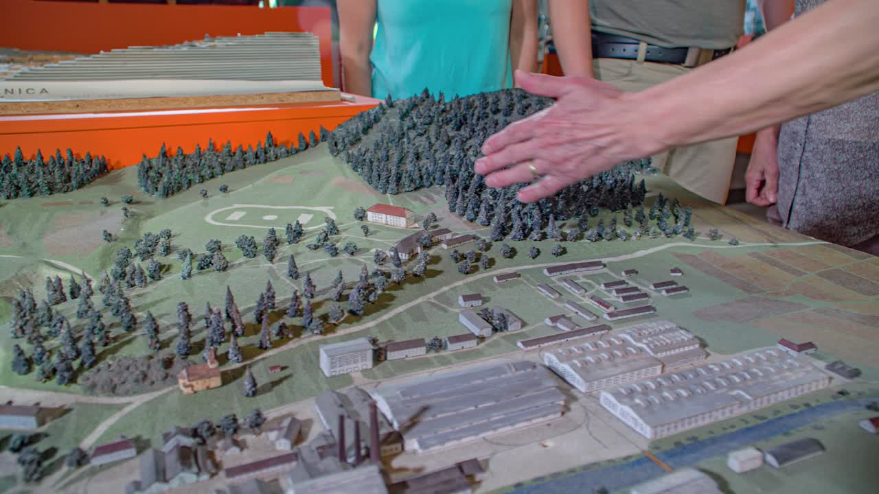 group of people view a scale model of the town. Guide explain the details