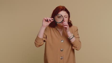 Investigator-researcher-woman-with-magnifying-glass-near-face,-looking-into-camera-with-big-zoom-eye