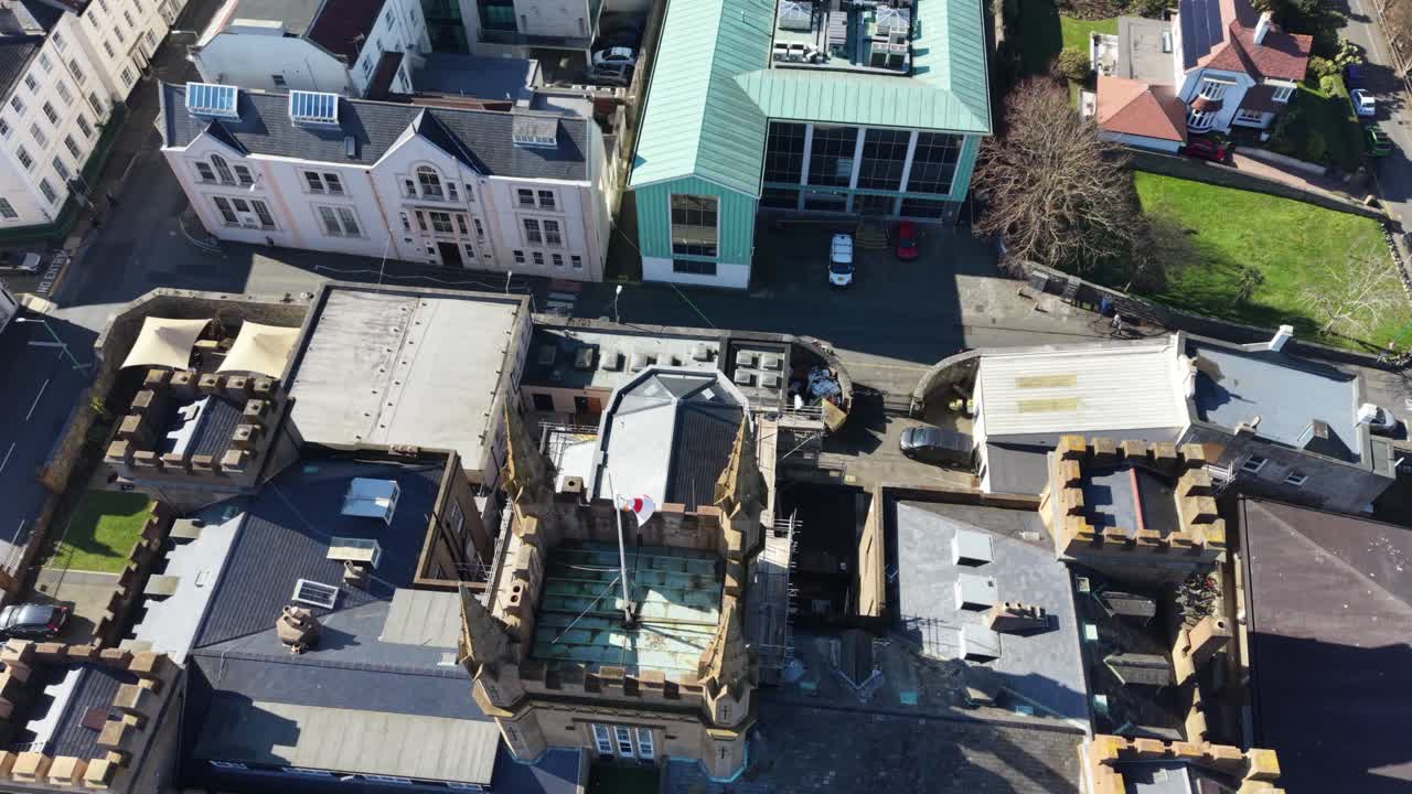 Elizabeth College St Peter Port Guernsey overhead footage of its beautiful tower with flag flying ,starting from town views and ending directly overhead in late afternoon sun