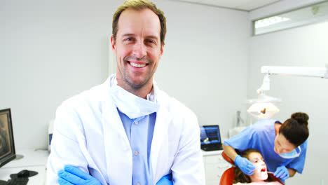 Dentist-standing-with-arms-crossed-in-clinic