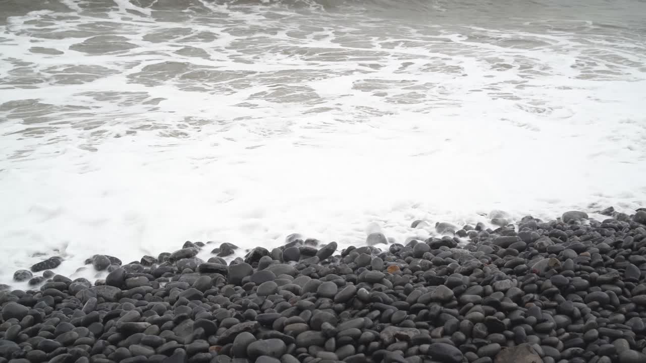 사우스 웨일즈 던레이븐 베이의 바위 해변 위로 튀는 겨울 조수를 가로질러 오른쪽에서 왼쪽으로 팬