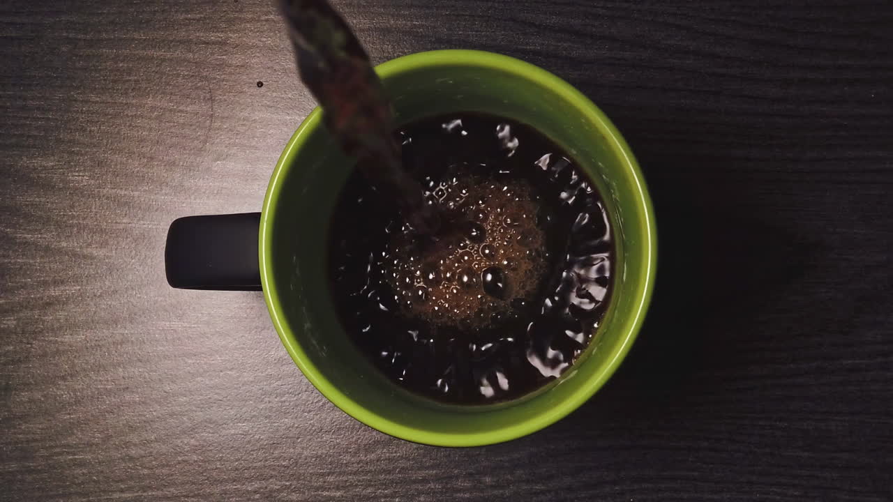 Video al rallentatore dall'alto di caffè versato in una tazza di ceramica