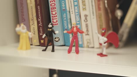 small figures on a bookshelf