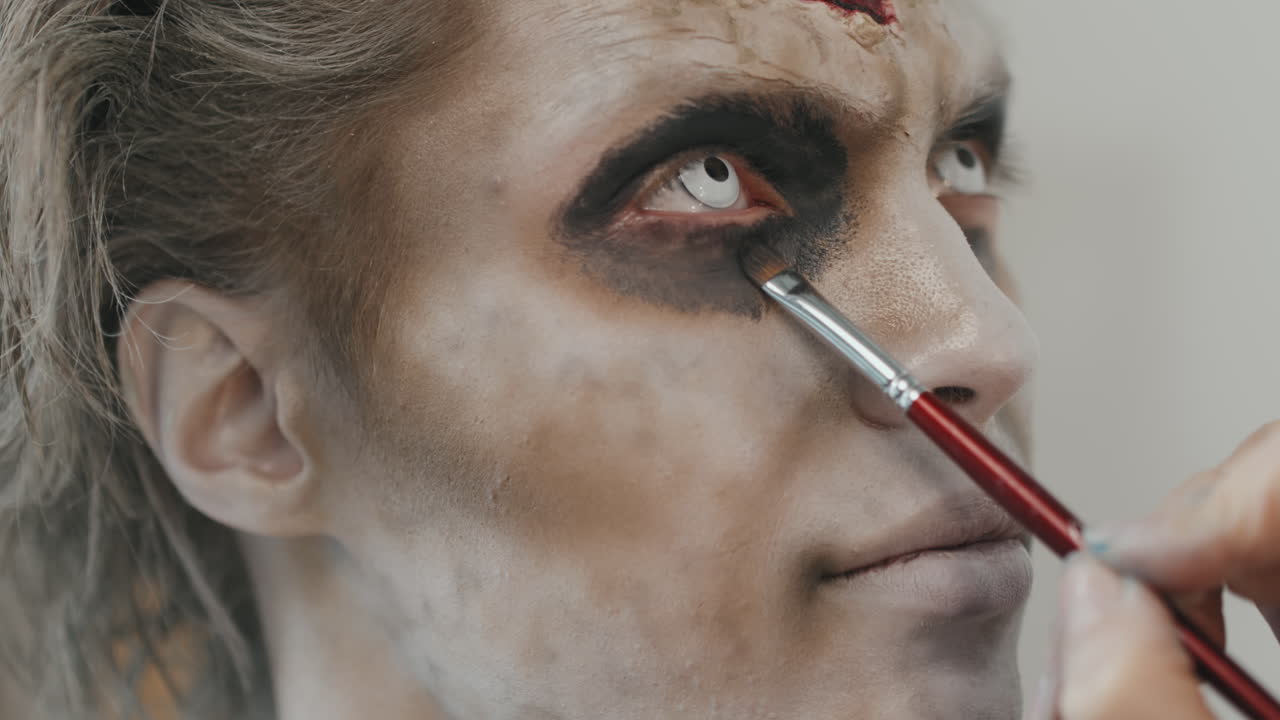 Unrecognizable Artist Doing SFX Makeup on Man