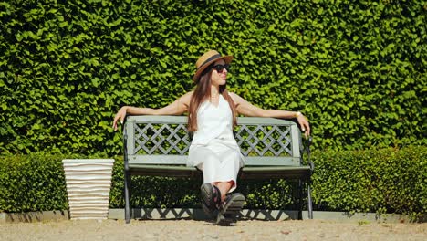 slow motion portrait of woman near manicured hedge in french baroque garden
