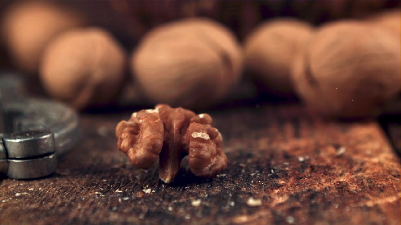 Shelled Walnut Falling in Super Slow Motion onto Rustic Wood