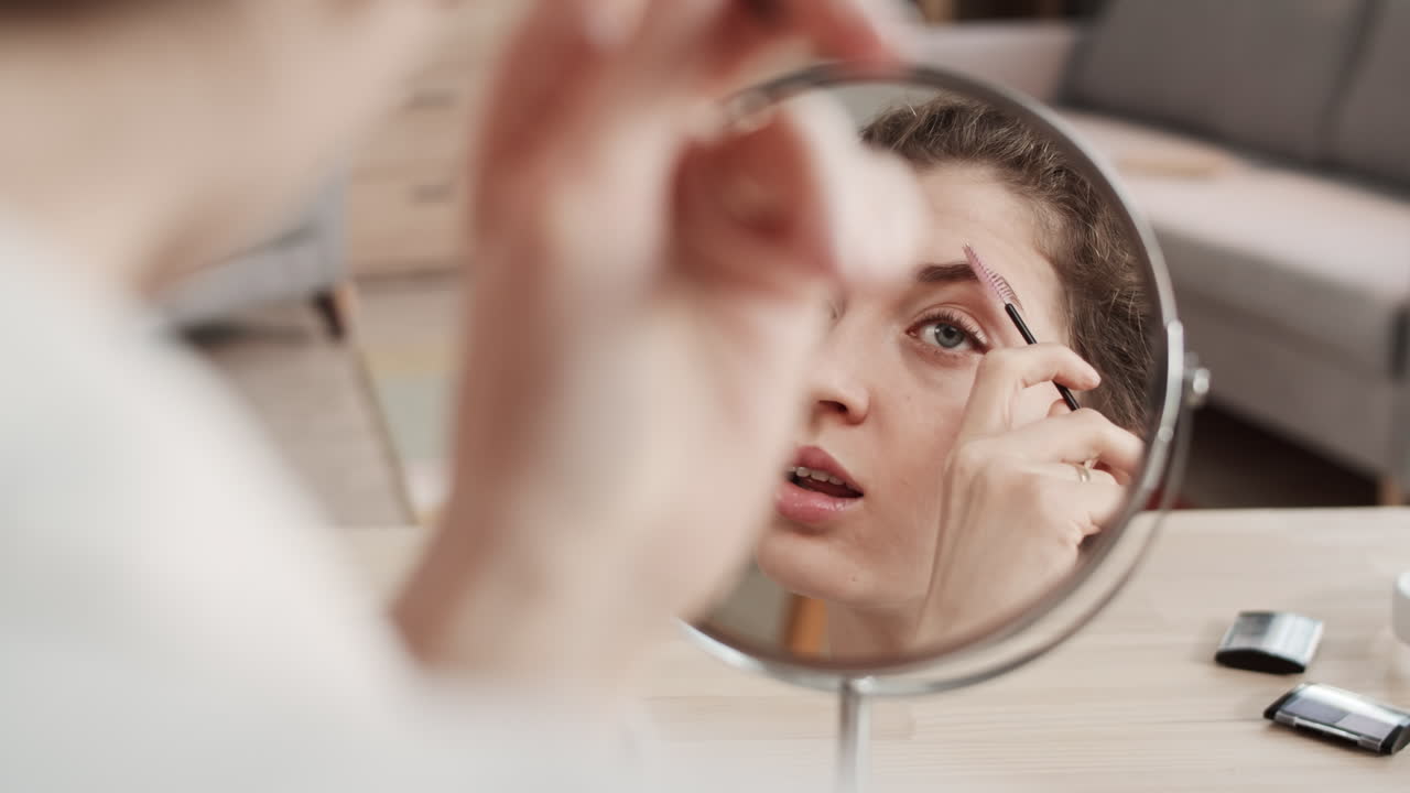 Woman Looking in Mirror Doing Makeup