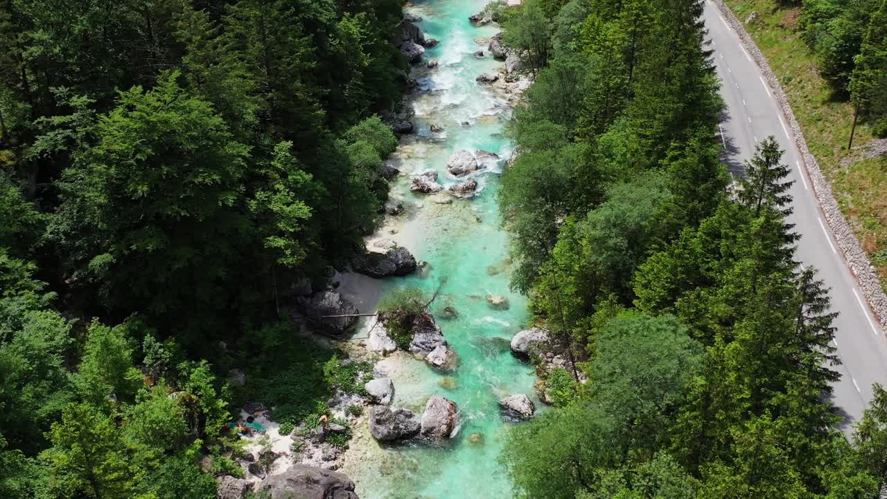 Vista aerea di un bellissimo fiume dalle acque turchesi che scorre lungo la strada di montagna di un parco nazionale.