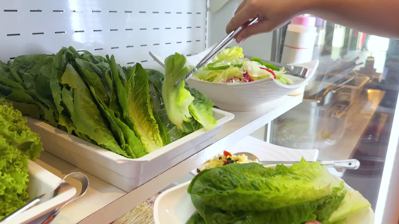 Picking fresh lettuce at a salad bar